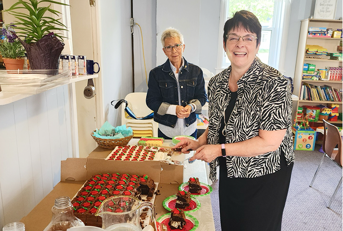 Woman laughing while cutting a cake