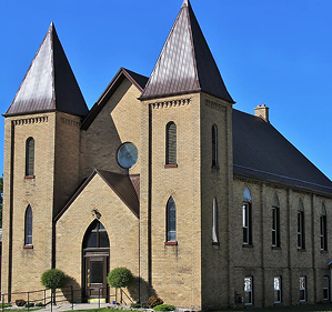 Yellow bricked church with towers, bright blue sky